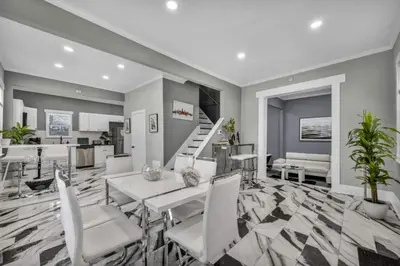 a living room with a table and chairs and stairs at Modern Luxury in Tremont - 6Bed 3bath Fee parking in Cleveland