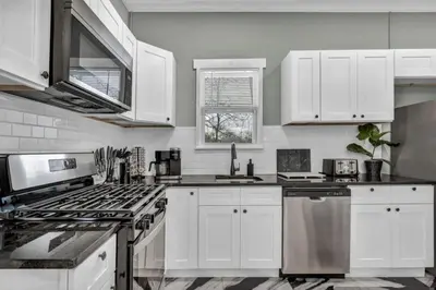 a kitchen with white cabinets and a stove top oven at Modern Luxury in Tremont - 6Bed 3bath Fee parking in Cleveland
