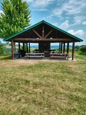a picnic shelter with benches in a field at Coschocton Hills - 2 Luxury Log Cabins - Lake in Coshocton
