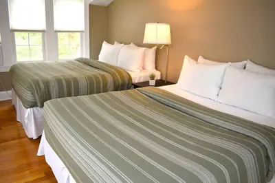 a hotel room with two beds and two windows at The House Hotels - Acadia Farms in Northfield