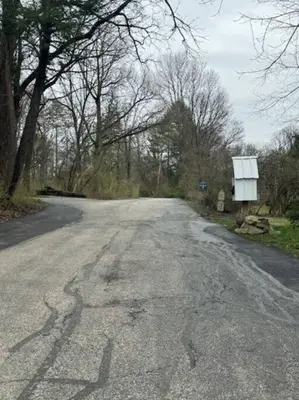 an empty road with a sign in the middle at The House Hotels - Acadia Farms in Northfield