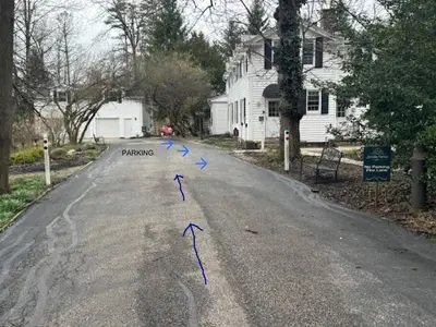 a street with blue arrows in the middle of the road at The House Hotels - Acadia Farms in Northfield