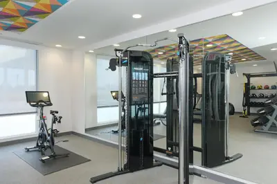 a gym with several tread machines and a television at Home2 Suites By Hilton Lima in Lima