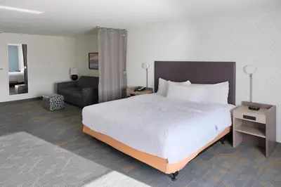 a hotel room with a bed and a couch at Home2 Suites By Hilton Lima in Lima