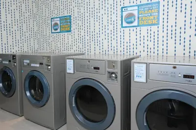 three washing machines are lined up in a laundry room at Home2 Suites By Hilton Lima in Lima