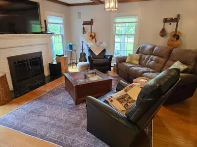 a living room with leather furniture and a fireplace at Large private retreat near Summit Lake in New Castle