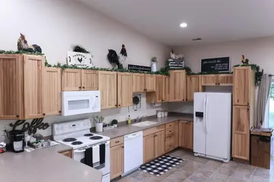 a kitchen with wooden cabinets and a white refrigerator at Maple Lawn in Moores Hill