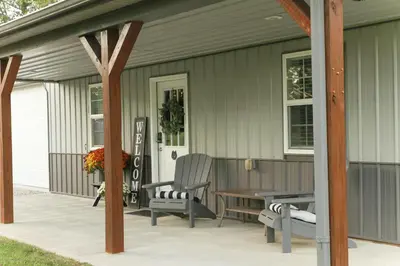 a patio with a table and chairs on a house at Maple Lawn in Moores Hill