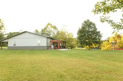 a large yard with a building and a playground at Maple Lawn in Moores Hill