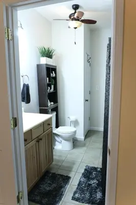 a bathroom with a toilet and a sink and a ceiling fan at Maple Lawn in Moores Hill