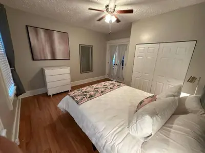 a bedroom with a white bed with a ceiling fan at Charming 2BR Home with Office in Cleveland