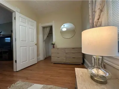 a room with a table with a lamp and a mirror at Charming 2BR Home with Office in Cleveland