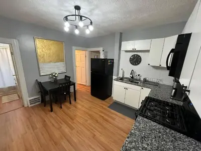 a kitchen with a table and a black refrigerator at Charming 2BR Home with Office in Cleveland