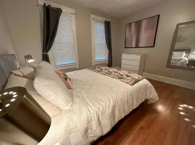 a bedroom with a large bed with white sheets and pillows at Charming 2BR Home with Office in Cleveland