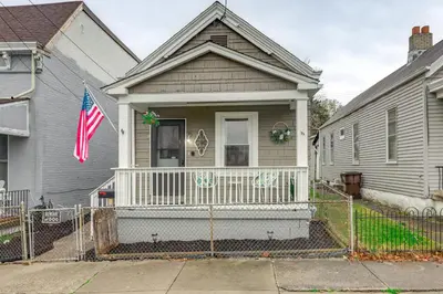 a house with an american flag on the front porch at 3 Mi to Dtwn Covington Getaway with Backyard in Covington