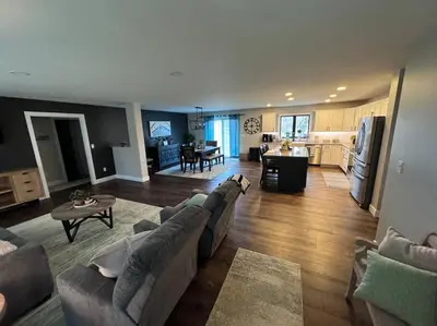 a large living room with a couch and a kitchen at Beck Lake House in Kelleys Island