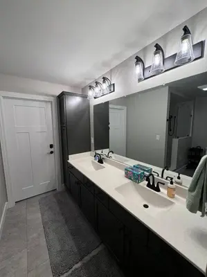 a bathroom with two sinks and two mirrors at Beck Lake House in Kelleys Island