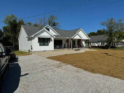 a white house with a driveway in front of it at Beck Lake House in Kelleys Island