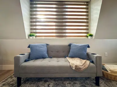 a couch in a living room with a window at Modern & Cozy Downtown Apartment in Cincinnati in Cincinnati