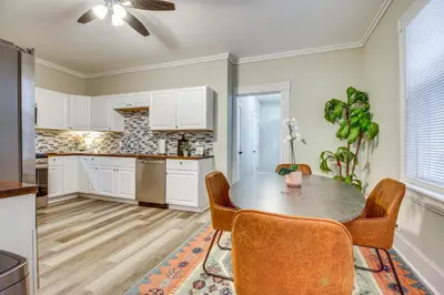 a kitchen with white cabinets and a table and chairs at 2 Mi to Dtwn Cincinnati Home with Fenced Yard! in Covington