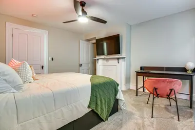 a bedroom with a bed and a desk and a chair at 2 Mi to Dtwn Cincinnati Home with Fenced Yard! in Covington