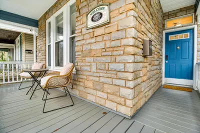 a brick house with a blue door and chairs on a porch at 2 Mi to Dtwn Cincinnati Home with Fenced Yard! in Covington