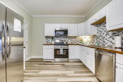 a kitchen with white cabinets and stainless steel appliances at 2 Mi to Dtwn Cincinnati Home with Fenced Yard! in Covington