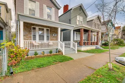 a house with a porch with a white railing at 2 Mi to Dtwn Cincinnati Home with Fenced Yard! in Covington