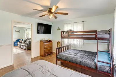 a bedroom with two bunk beds and a living room at Walk to Sandusky Bay Home with Hot Tub and Fire Pit! in Sandusky