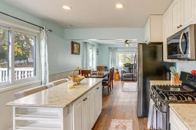 a kitchen with a counter and a living room at Walk to Sandusky Bay Home with Hot Tub and Fire Pit! in Sandusky