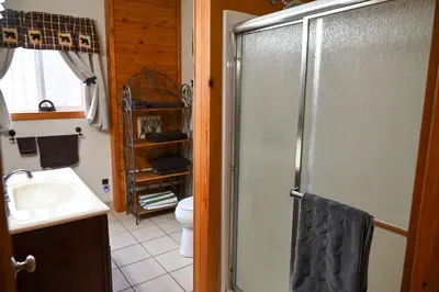 a bathroom with a shower and a sink at A Beary Cozy Cabin in Hocking Hills in Laurelville