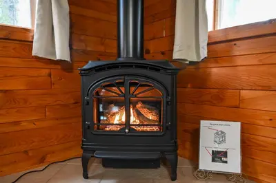 a stove with a fire in a room at A Beary Cozy Cabin in Hocking Hills in Laurelville