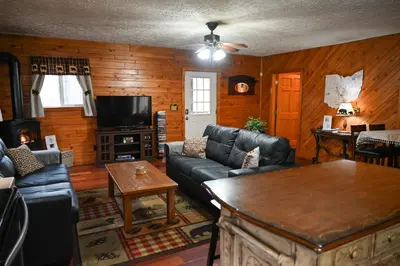 a living room with a couch and a table at A Beary Cozy Cabin in Hocking Hills in Laurelville