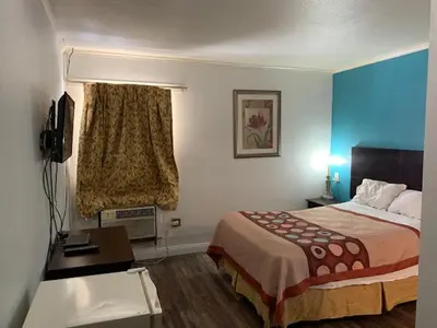 a hotel room with a bed and a desk at Holiday Motel in Columbus