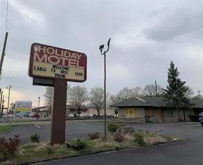 a motel sign in front of a parking lot at Holiday Motel in Columbus