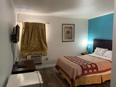 a hotel room with a bed and a desk at Holiday Motel in Columbus