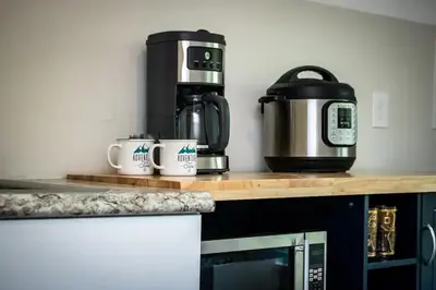 a kitchen counter with a coffee maker and coffee cups at Cozy studio near Cleve Clinic Case in Cleveland Heights