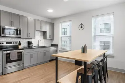 a kitchen with a wooden table and a dining room at Cozy 10BR 10BA combined Apartment Near Downtown Cincinnati in Cincinnati