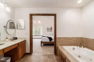 a bathroom with a tub and a sink and a mirror at Weekend Retreat Hot Tub Game Room Putt Putt in Lancaster