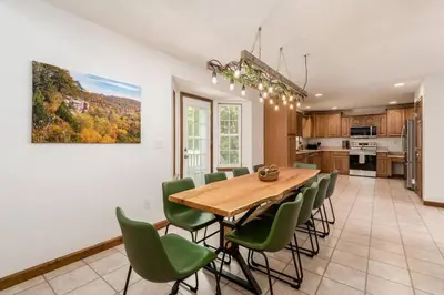 a kitchen and dining room with a wooden table and green chairs at Weekend Retreat Hot Tub Game Room Putt Putt in Lancaster