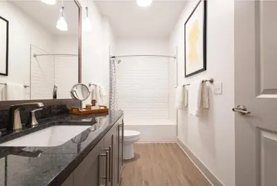 a white bathroom with a sink and a toilet at Cozy 6BR 6BA combined Apartments Near Downtown Cincinnati in Cincinnati