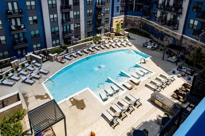 an overhead view of a large swimming pool with lounge chairs at Cozy 6BR 6BA combined Apartments Near Downtown Cincinnati in Cincinnati