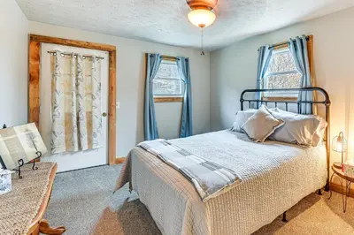 a bedroom with a bed with blue walls and windows at On 220 Acres! Hot Tub Haven in West Liberty in West Liberty