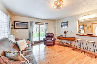a living room with a leather couch and a table at On 220 Acres! Hot Tub Haven in West Liberty in West Liberty