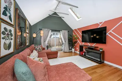 a living room with a couch and a flat screen tv at Lux Ohio City Gem in Cleveland