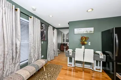 a living room with green walls and a table and chairs at Lux Ohio City Gem in Cleveland