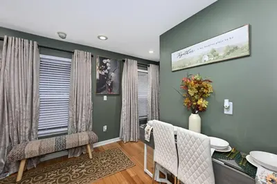 a living room with green walls and a table and chairs at Lux Ohio City Gem in Cleveland
