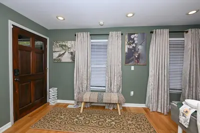 a living room with a chair and a door at Lux Ohio City Gem in Cleveland