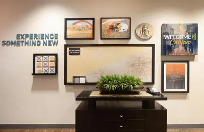 a wall with pictures and a tv on a table at Home2 Suites by Hilton Canton in North Canton