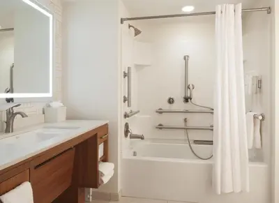 a bathroom with a tub and a shower with a sink at Home2 Suites by Hilton Canton in North Canton